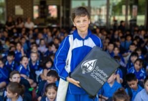 A photo of Volodymyr in front of the Regina Coeli school assembly